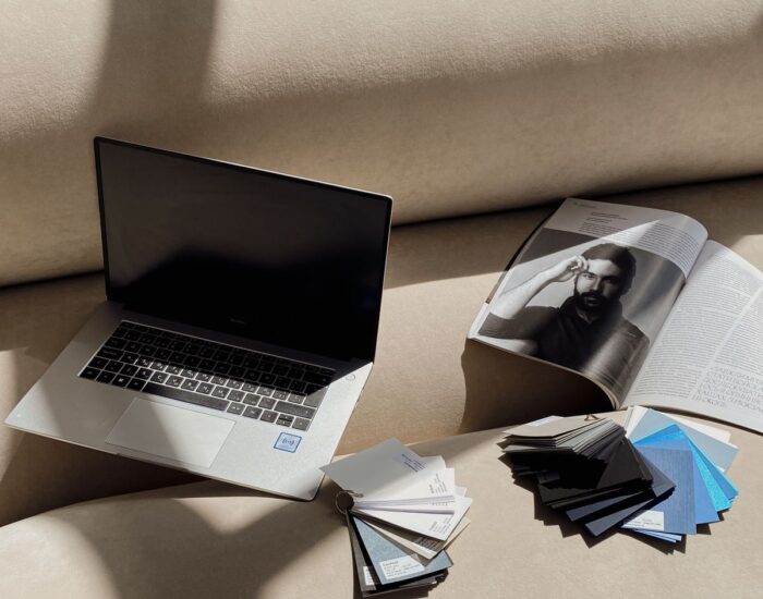 Otvoren časopis, laptop i uzorci boja za pripremu grafičkog materijala