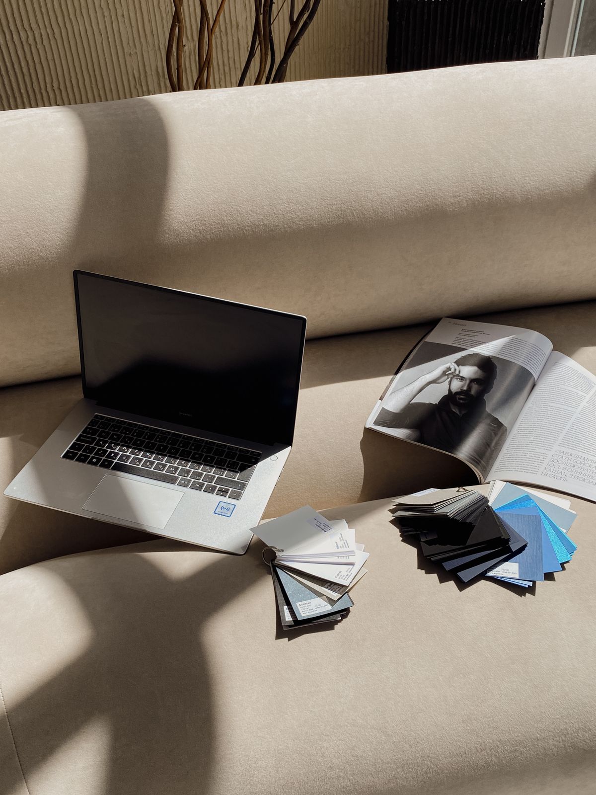 Otvoren časopis, laptop i uzorci boja za pripremu grafičkog materijala